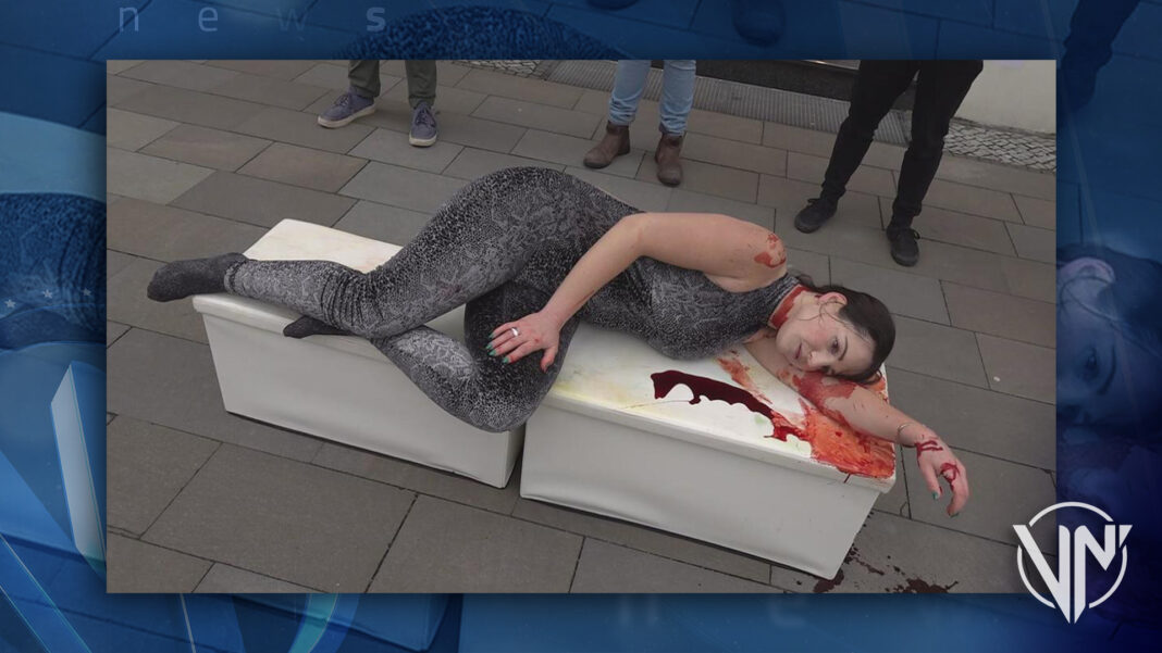 Activista posa como una serpiente muerta frente a tienda Gucci