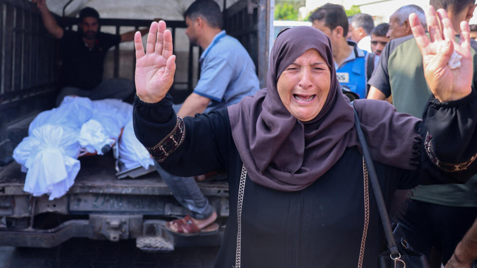 Mujer llora al ver víctimas mortales de bombardeos israelíes en Gaza.